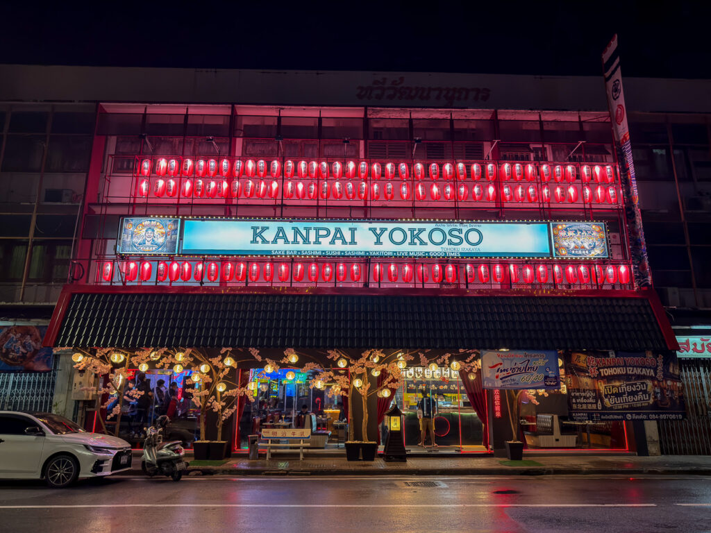 Fachada iluminada del restaurante japonés Kanpai Yokoso en Korat