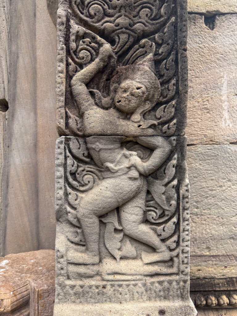 Relieve de una figura con un brazo levantado entre motivos vegetales en Phimai