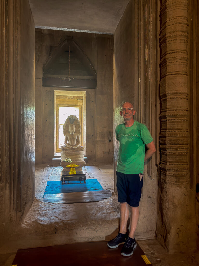Posando junto a una puerta tallada, con una imagen de Buda al fondo